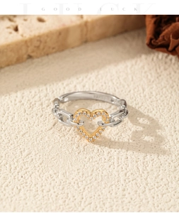 Macro view of S925 silver heart ring with pave diamonds and gold-tone chain link band
