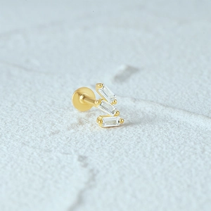 Macro detail of gold S925 silver flat back earring with three tiered rectangular zircons