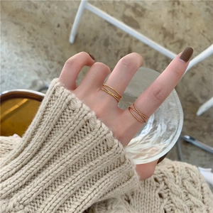 French style 18K gold-plated triple layered interlaced ring worn on a finger