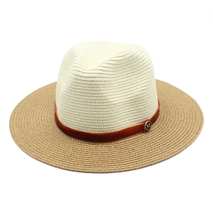 Detail of two-tone woven straw hat with suede band and gold M letter metal buckle