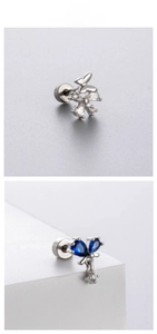 Macro detail of butterfly ear studs with blue and white zircon in silver titanium steel