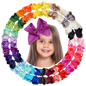 Detail view of colorful ribbon hair bows for kids in various shades and a large purple bow
