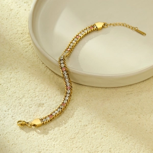 Detail of a gold stainless steel bracelet with three rows of pink and white zircons