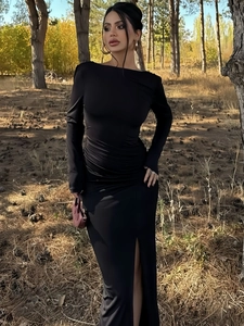 Detail of the side ruching and elegant leg slit on this black slim-fit maxi dress