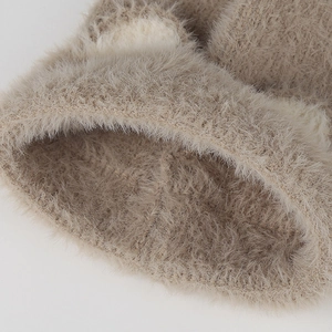 Close-up of fluffy khaki knit beanie showing soft plush texture and detailed craftsmanship