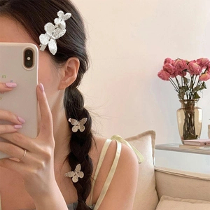 Three silver butterfly hair clips on model side hair for elegant sweet styling