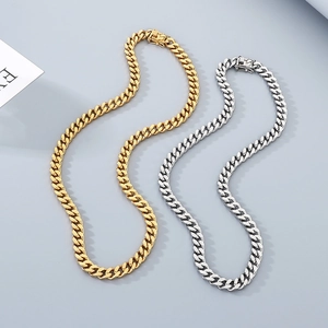 Detail view of gold and silver Cuban link necklaces with high-polished metal finish