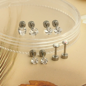 Detail view of heart star and round zircon stud earrings set in stainless steel