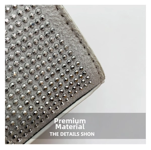 Macro shot of silver rhinestone embellishments on light gray textured fabric detail