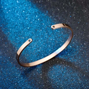 Detailed close-up of rose gold C-shaped stainless steel bracelet with heart cutouts