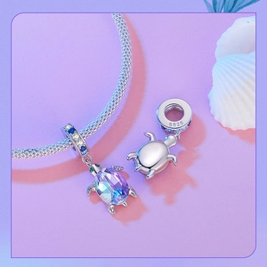 Macro view of S925 silver sea turtle charm with purple crystal inlay on a bracelet