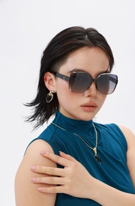 Detail of square polarized sunglasses with gradient lenses and gold logo on the temple