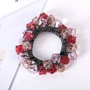 Detail of handmade hair tie featuring faceted burgundy and pink crystal beads on elastic band