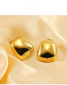 Dettaglio macro di orecchini a perno geometrici quadrati placcati oro 18K su seta