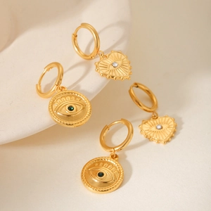 Macro shot of gold stainless steel devil eye earrings with heart and round charms