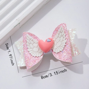 Close-up of pink glitter bow hair clip with heart and wings, 8cm wide by 5cm high