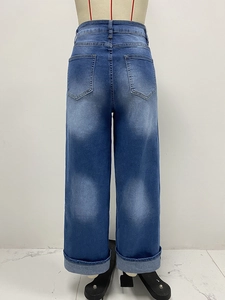 Dettaglio dei jeans blu a vita alta con eleganti orli delle gambe dritti con risvolto