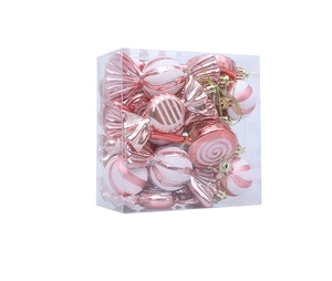Macro view of pink and white candy-shaped Christmas tree ornaments with golden strings