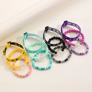 Detail of multi-layered bracelets with turquoise crosses and colorful clay beads
