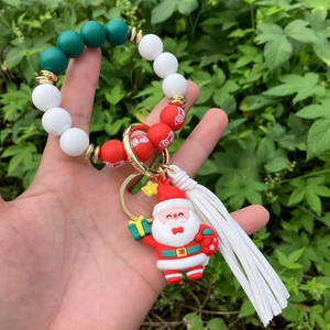Detail of Christmas beaded keychain with Santa pendant and tassel held outdoors