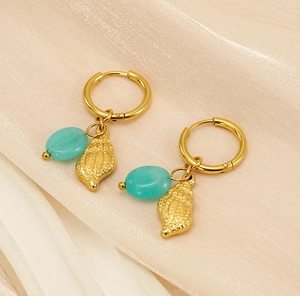 Detail of bohemian gold hoop earrings with turquoise beads and textured conch shell charms