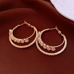 Luxurious gold plated double hoop earrings with square zircon stones on red velvet background