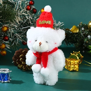 Close-up of a white plush bear wearing a red LOVE hat and scarf with Christmas decor