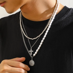 Three-layer layered necklace featuring baroque pearls, silver cuban links, and cross pendant