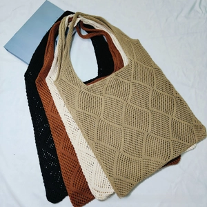 Close-up of four knitted tote bags in neutral colors with hollow diamond grid patterns
