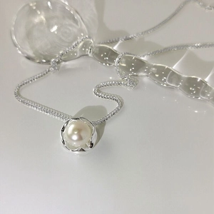 Elegant S925 silver necklace with single white pearl in wave setting on beige background