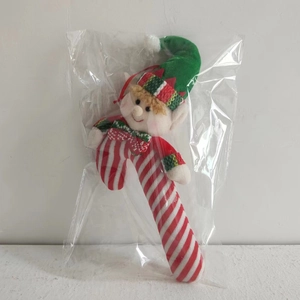 Close-up of a Christmas elf candy cane plush ornament with red and white stripes