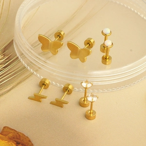 Detail of gold barbell earrings set with opal, zircon, butterfly and lightning shapes