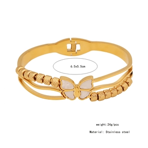 Detailed view of golden stainless steel bracelet with white butterfly and size specs