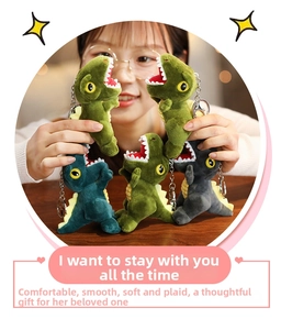Close-up of soft dinosaur plush keychains in green and grey with metal clips
