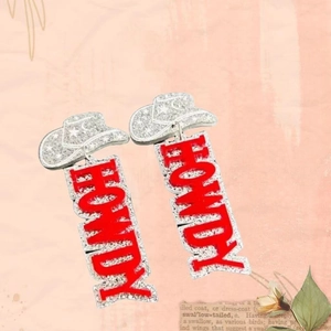 Sparkly rhinestone cowboy hat earrings with red glitter HOWDY drop on pink aesthetic background