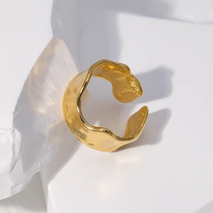 Macro shot of gold hammered finish on an irregular wave adjustable stainless steel ring