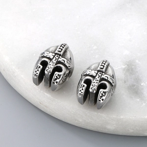 Macro detail of textured silver Spartan helmet beads for jewelry making on marble