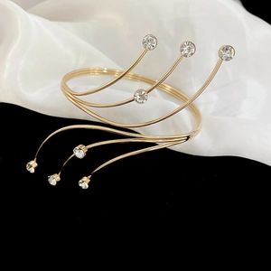 Detalle del brazalete multicapa chapado en oro con brillantes cristales redondos incrustados