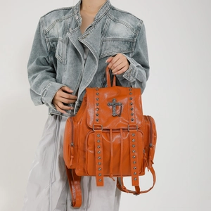 Orange punk backpack with rivets and metal cross pendant shown on model