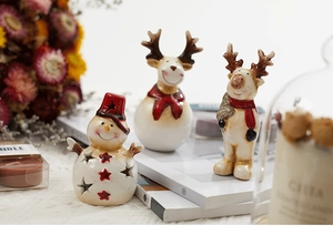 Detail of ceramic Christmas snowman and reindeer figurines with warm home decor lighting