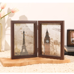 Close-up of a double folding dark wood picture frame with retro Eiffel Tower art print