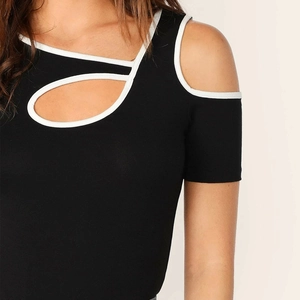 Detail of black slim fit top featuring white contrast piping and shoulder cut-out design