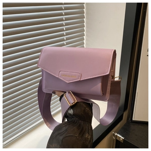 Detail of light purple crossbody bag with metal logo, wide nylon strap and flap closure