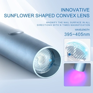 Macro detail of portable UV nail lamp with blue metallic finish and convex lens