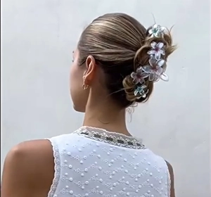 Iridescent flower hair claws set in clear floral design on woman's blonde hair bun