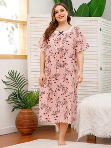 Detail of light pink nightgown with floral print, white lace neckline and bow accent
