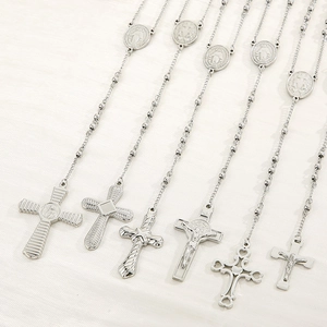 Close-up of six unique stainless steel rosary cross pendants on bead chains