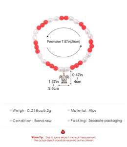 Detail of red and white beaded bracelet with vintage turtle charm and alloy elements