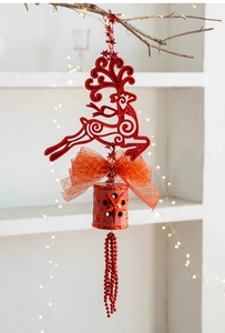 Dettaglio macro della campana di Natale rossa con renna traforata e motivi a stelle