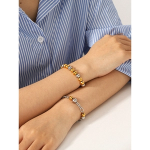 Bracciale di perle in acciaio inossidabile bicolore oro e argento indossato al polso